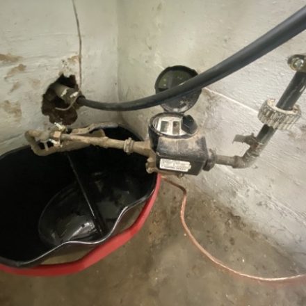 Sump and water service connection in a basement