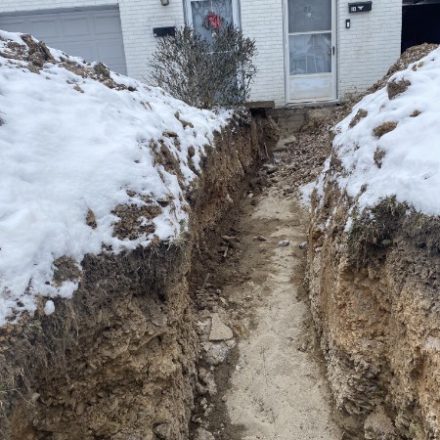 Trench alongside a house in the snow