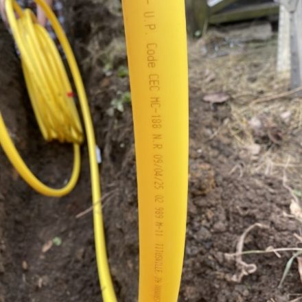 New yellow gas line coiled in an open trench